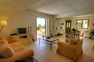 a living room with two couches and a tv at Villa Telina Ideales Resort in Kefallonia