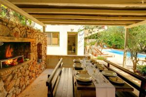 a dining room with a table and a stone wall at Villa Telina Ideales Resort in Kefallonia