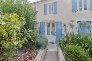 a house with a blue door and some plants at Les Hirondelles Archiac in Archiac