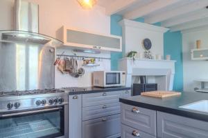 a kitchen with a stove and a microwave at Les Hirondelles Archiac in Archiac
