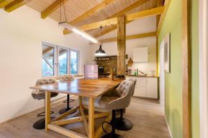 a kitchen and dining room with a wooden table and chairs at Fewo am Flämingrand in Zahna-Elster