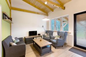 a living room with chairs and a tv and a table at Fewo am Flämingrand in Zahna-Elster