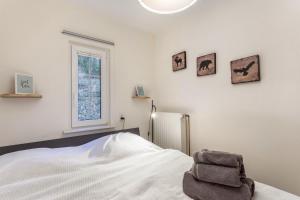 a white bedroom with a bed and a window at Homertstuebchen in Eslohe