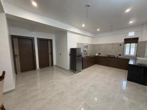 a large kitchen with a refrigerator in a room at Kaashi Flora Whitehouse-9BHK in Varanasi