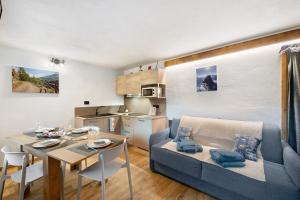 a living room with a dining table and a kitchen at Maison Olga in Valtournenche
