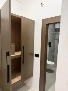 a bathroom with wooden cabinets and a toilet at Kaashi Flora Whitehouse-9BHK in Varanasi +17 photos