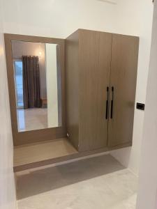 a wooden cabinet with a mirror in a room at Kaashi Flora Whitehouse-9BHK in Varanasi
