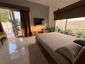 a bedroom with a large bed and a large window at Kaashi Flora Whitehouse-9BHK in Varanasi