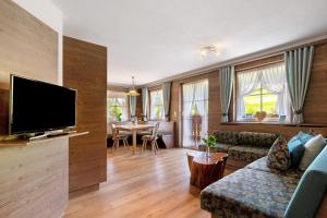 a living room with a couch and a tv at Danielenhof in Freiamt