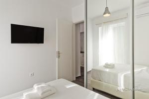 a white room with two beds and a mirror at Helios Apartment 2 in Karpathos