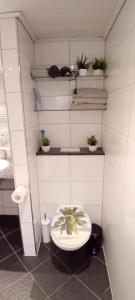 a bathroom with a toilet with a plant on it at Fewo Nied in Rehlingen-Siersburg