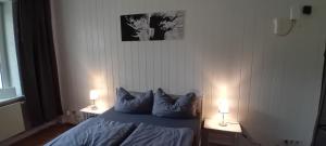a bedroom with a blue bed with two lamps at Fewo Nied in Rehlingen-Siersburg