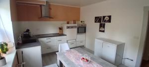 a kitchen with white cabinets and a table in it at Fewo Nied in Rehlingen-Siersburg
