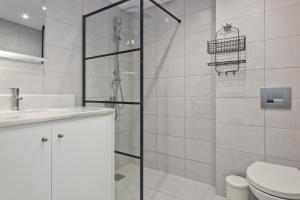 a bathroom with a shower and a toilet and a sink at Helios Apartment 2 in Karpathos