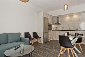 a living room with a couch and chairs and a kitchen at Helios Apartment 2 in Karpathos