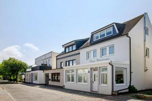 a white building with windows on a street at Huus Nördernee 2 in Norderney