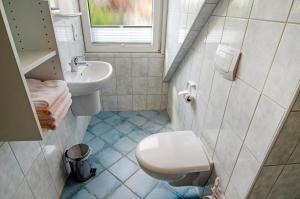 a bathroom with a white toilet and a sink at Huus Nördernee 2 in Norderney +14 photos