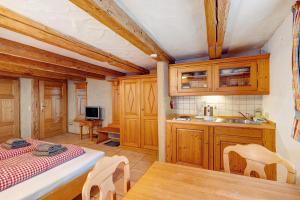 a kitchen with wooden cabinets and a bed and a table at Holzwurm Apartments in Sasbachwalden