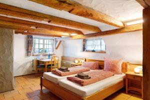 a bedroom with a bed and a table and windows at Holzwurm Apartments in Sasbachwalden