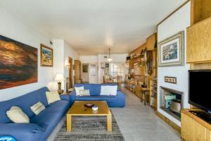 a living room with a blue couch and a fireplace at Carrer del Mar in Palamós