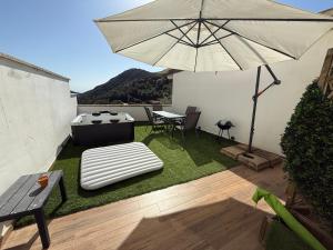 a patio with an umbrella and a table and chairs at Sardinia house with beautiful view near sea in Brunella