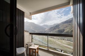 a room with a balcony with a view of a mountain at Appartement N° 46 in Les Menuires