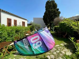 a colorful umbrella sitting on the grass in a yard at Stagnone Area Zero in Birgi Vecchi