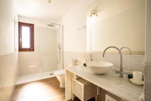 a white bathroom with a sink and a toilet at The Cube in Zahara de los Atunes +25 photos