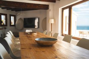 a dining room with a large wooden table with chairs at The Cube in Zahara de los Atunes