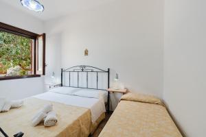 a bedroom with two beds and a window at Baglio Montoleone in Castelluzzo