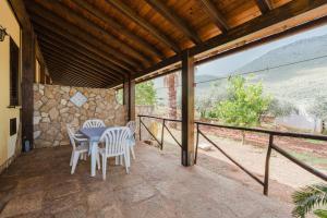 a patio with a table and chairs on a balcony at Baglio Montoleone in Castelluzzo
