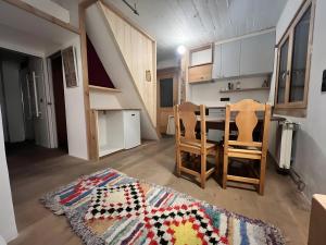 a living room with a table and chairs and a rug at Au Soleil in Séez