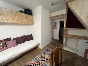 a living room with a white couch and a staircase at Au Soleil in Séez +4 photos