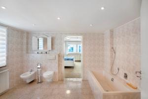 a bathroom with a tub and a toilet and a sink at Wohnung zum Hirschen in Gräfelfing +22 photos