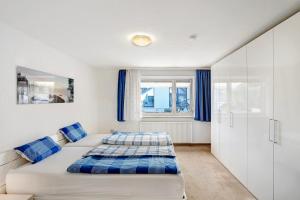 a white bedroom with a bed and a window at Wohnung zum Hirschen in Gräfelfing