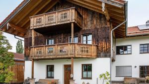 a wooden house with a balcony on top of it at Wohnung Staufenblick in Freilassing