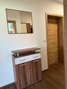 a bathroom with a mirror and a wooden vanity at Ferienwohnung Adelsried 1 in Adelsried +23 photos