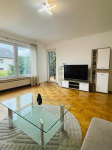 a living room with a television and a glass coffee table at Ferienwohnung Adelsried 1 in Adelsried