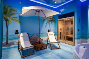 a room with two chairs and an umbrella and a tub at Hotel Art Village in Casoria