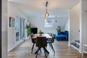 a dining room and living room with a table and chairs at Fewo Ebringen Vogesenblick in Ebringen