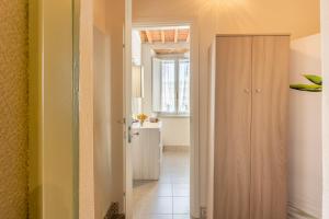 ein Flur mit einer Tür, die zu einem Zimmer mit Fenster führt in der Unterkunft Mangiafuoco in Collodi + 12 Fotos