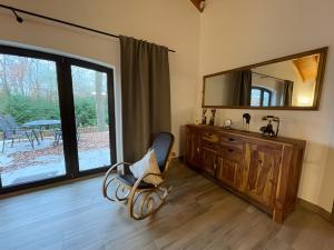a bathroom with a chair in front of a mirror at Ferien-Schindeldorf in Stromberg