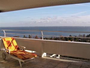 a chair on a balcony with a view of the ocean at Wellness Penthouse Meerblick in Sierksdorf