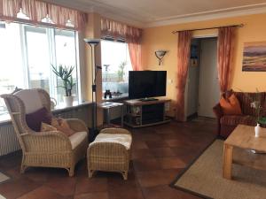 a living room with two chairs and a television at Wellness Penthouse Meerblick in Sierksdorf
