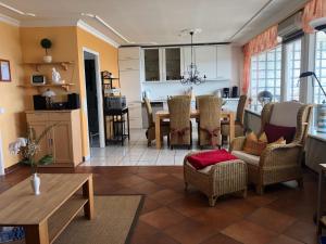 a kitchen and living room with a table and chairs at Wellness Penthouse Meerblick in Sierksdorf