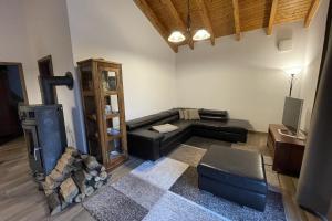 a living room with a black couch and a tv at Ferien-Schindeldorf in Stromberg