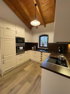 a kitchen with white cabinets and a black counter top at Ferien-Schindeldorf in Stromberg +21 photos