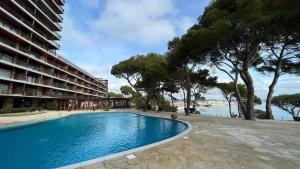 a swimming pool next to a large building at Eden Mar Calonge Girona in Calonge