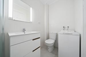 a white bathroom with a toilet and a sink at Formentor 863 in Salou +12 photos