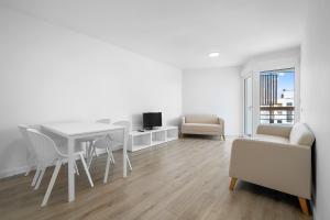 a white living room with a table and chairs at Formentor 863 in Salou